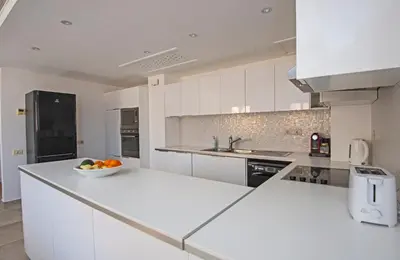a white kitchen with a bowl of fruit on the counter at Soma Bay Seafront Luxury Appartement in Hurghada