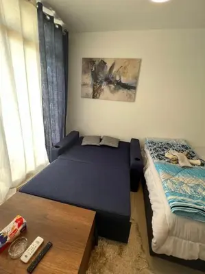 a bedroom with a bed and a table and a window at Brand new studio at G-Cribs ElGouna in Hurghada