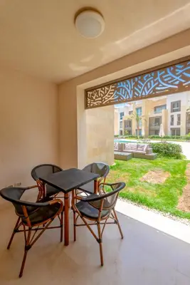 a dining room with two chairs and a table and a window at Cozy 1-Bedroom Apartment in Mangroovy, El Gouna. Private terrace, garden and pool access in Hurghada