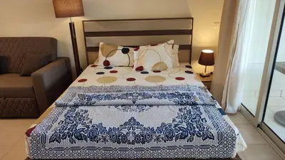 a bedroom with a bed with a blue and white blanket at veranda sahl hasheesh resort in Hurghada