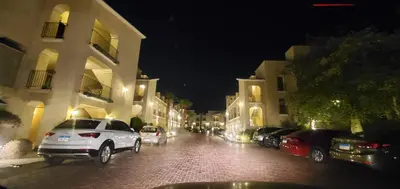 a city street at night with cars parked next to buildings at veranda sahl hasheesh resort in Hurghada