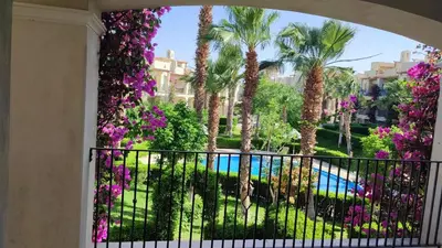 a balcony with purple flowers and a swimming pool at veranda sahl hasheesh resort in Hurghada