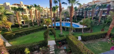 a resort yard with a pool and trees and bushes at veranda sahl hasheesh resort in Hurghada