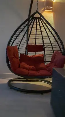 a red couch sitting in a hanging chair at Aldau heights Kevin in Hurghada