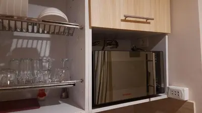 a kitchen with a refrigerator and some glasses on a shelf at Aldau heights Kevin in Hurghada