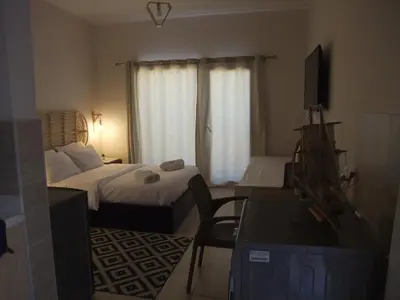 a bedroom with two beds and a desk and a television at Aldau heights Kevin in Hurghada