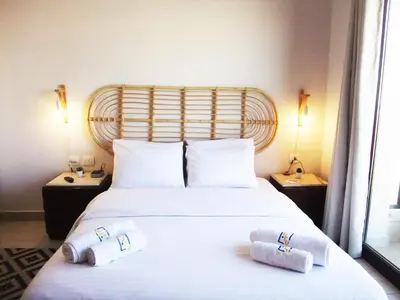 a bedroom with a large white bed with towels on it at Aldau heights Kevin in Hurghada