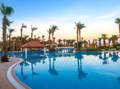 a large swimming pool with palm trees in a resort at veranda sahl hasheesh resort studio in Hurghada