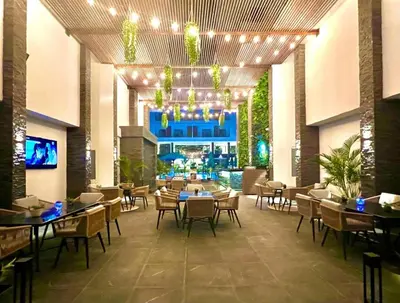 a restaurant with tables and chairs and a pool at 2 Bed Resort Apt-Sleeps 4-Balcony-Hotel Services in Hurghada