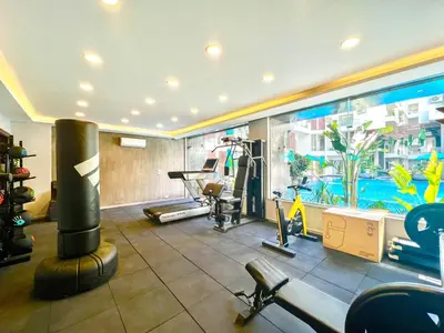 a gym with exercise equipment and a swimming pool at 2 Bed Resort Apt-Sleeps 4-Balcony-Hotel Services in Hurghada
