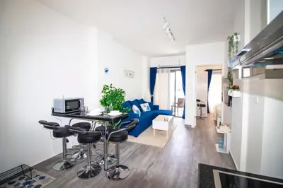 a living room with a table and a blue couch at 2 Bed Resort Apartment - Sleeps 4 - Hotel Services in Hurghada