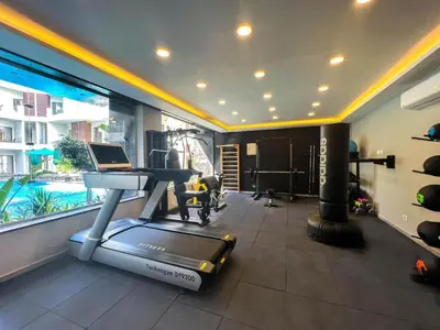 a room with a gym with a treadmill and a pool at 2 Bed Resort Apartment - Sleeps 4 - Hotel Services in Hurghada