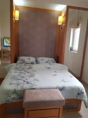 a bedroom with a bed with a white comforter at شقه غرفتين وصاله بالحديقه في فراندا سهل حشيش in Hurghada