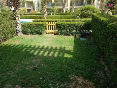 a shadow of a bench in a garden at شقه غرفتين وصاله بالحديقه في فراندا سهل حشيش in Hurghada