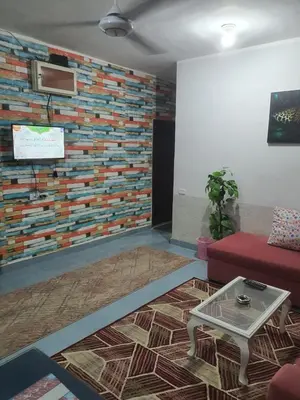 a living room with a red couch and a brick wall at Abeer Suites 3 basement in Hurghada