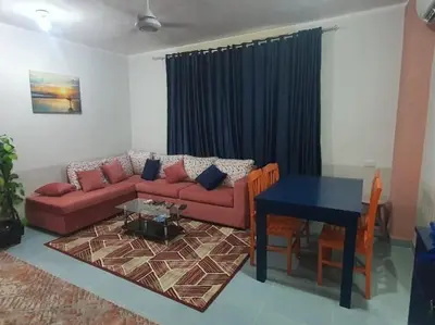 a living room with a red couch and a table at Abeer Suites 3 basement in Hurghada