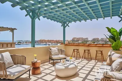 a patio with chairs and tables on a roof at BYTK - La Veranda in Hurghada