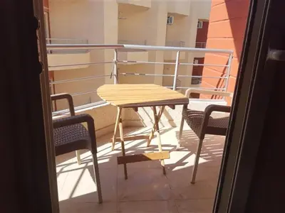 a wooden table and two chairs on a balcony at Chalet in Casablanca Beach Resort in Hurghada
