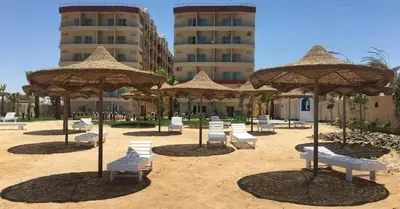 a group of chairs and umbrellas on a beach at Chalet in Casablanca Beach Resort in Hurghada