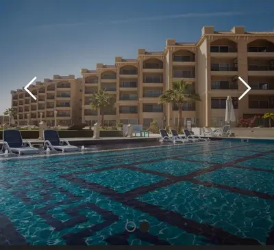 a hotel with a swimming pool in front of a building at Amazing 2 bedroom Selena Bay Hurghada in Hurghada