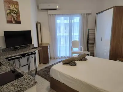 a bedroom with a bed and a flat screen tv at A Superb Studio Apartment in Hurghada