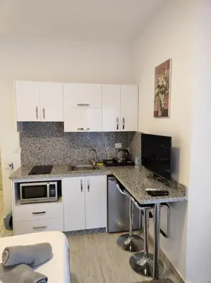 a kitchen with white cabinets and a counter top at A Superb Studio Apartment in Hurghada