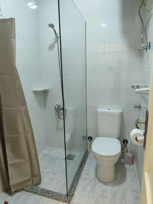 a bathroom with a toilet and a glass shower at A Superb Studio Apartment in Hurghada