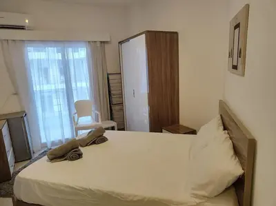 a bedroom with a large white bed and a window at A Superb Studio Apartment in Hurghada