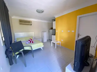 a living room with a bed and a tv at Moubark 6 Directly to the swimming pool in Hurghada