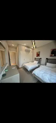a bedroom with two beds and a table in it at El Gouna 3 bedroom Penthouse Cyan in Hurghada