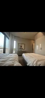 two white beds in a room with a window at El Gouna 3 bedroom Penthouse Cyan in Hurghada