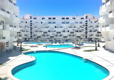 an apartment with a swimming pool in front of a building at ستوديو كومباوند طيبة فيو in Hurghada