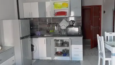 a small kitchen with white cabinets and a refrigerator at ستوديو كومباوند طيبة فيو in Hurghada
