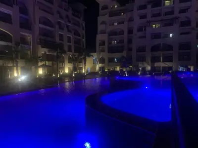 a swimming pool at night with blue lights at at Aldau luxury in Hurghada