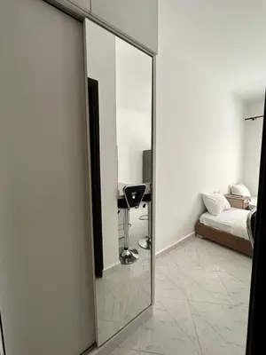 a mirror in a room with a bed and a couch at Уютное место рядом с променадом in Hurghada