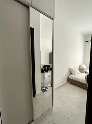 a mirror in a room with a bed and a couch at Уютное место рядом с променадом in Hurghada