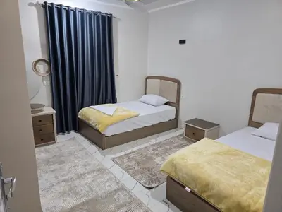 a bedroom with two beds and a window at Moon Adam hostel in ‘Ezbet Abu Ḥabashi