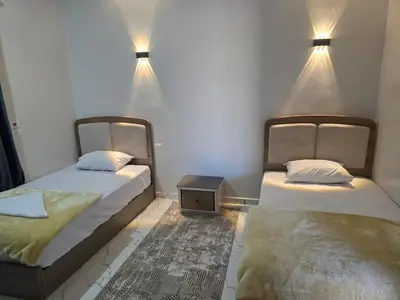 two beds in a room with lights on the wall at Moon Adam hostel in ‘Ezbet Abu Ḥabashi