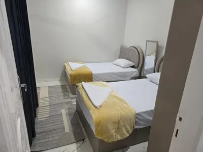 two twin beds in a room with a doorway at Moon Adam hostel in ‘Ezbet Abu Ḥabashi