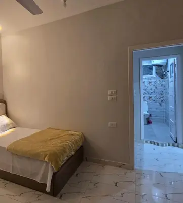 a bedroom with a bed and a door to a hallway at Moon Adam hostel in ‘Ezbet Abu Ḥabashi