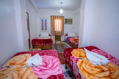 a hotel room with two beds and two chairs at Venus Hotel Luxor \u65e5\u672c\u4eba \u5927\u6b53\u8fce in Luxor