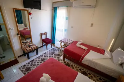 a hotel room with two beds and a mirror at Venus Hotel Luxor \u65e5\u672c\u4eba \u5927\u6b53\u8fce in Luxor