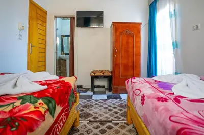 a room with two beds in a room with a door at Venus Hotel Luxor \u65e5\u672c\u4eba \u5927\u6b53\u8fce in Luxor
