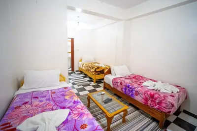 a room with two beds and a table in it at Venus Hotel Luxor \u65e5\u672c\u4eba \u5927\u6b53\u8fce in Luxor
