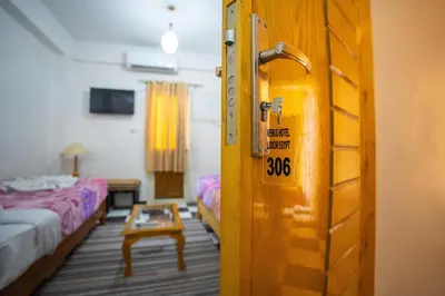 a room with two beds and a door with a sign at Venus Hotel Luxor \u65e5\u672c\u4eba \u5927\u6b53\u8fce in Luxor