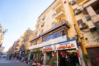 a building with a sign on the side of a street at Venus Hotel Luxor \u65e5\u672c\u4eba \u5927\u6b53\u8fce in Luxor