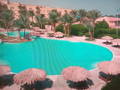 a swimming pool with umbrellas and a resort at Palma Resort Hurgáda,8P4J22Q, Hurgada Palma Resort, apartment K75, Al Ismaileya, in Hurghada