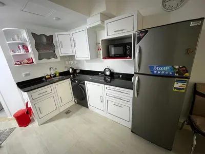 a small kitchen with a refrigerator and a microwave at Palma Resort Hurgáda,8P4J22Q, Hurgada Palma Resort, apartment K75, Al Ismaileya, in Hurghada