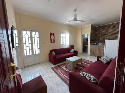 a living room with a red couch and a table at Skylen Hostel in Hurghada