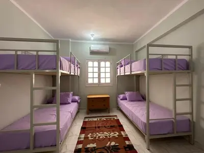 two bunk beds in a room with purple pillows at Skylen Hostel in Hurghada